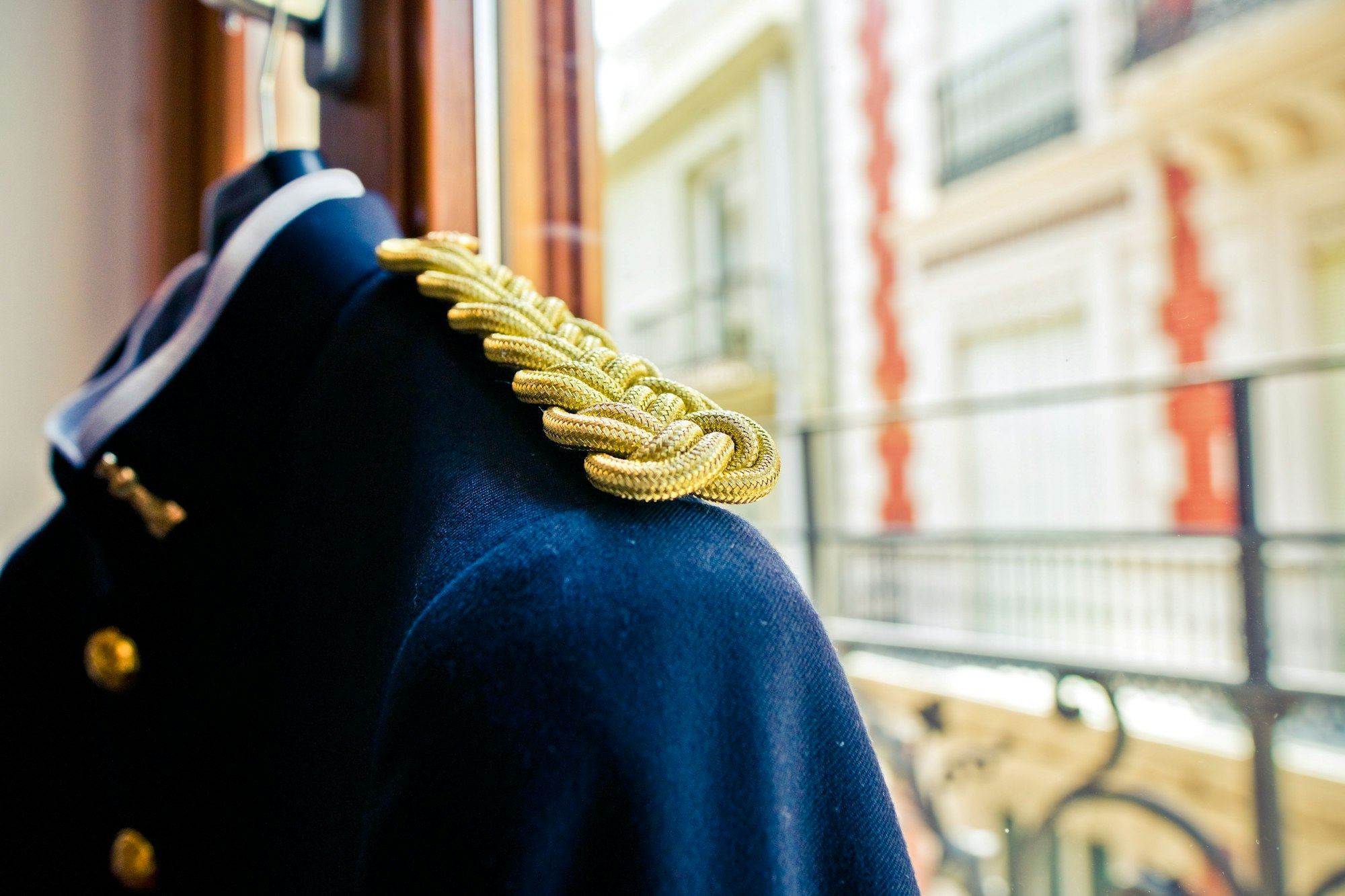 Detail of the embroidered golden insignia of a dark blue military man's suit.
